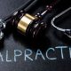 A stock photo for a stethoscope with the word 'Malpractice' written with the frame.