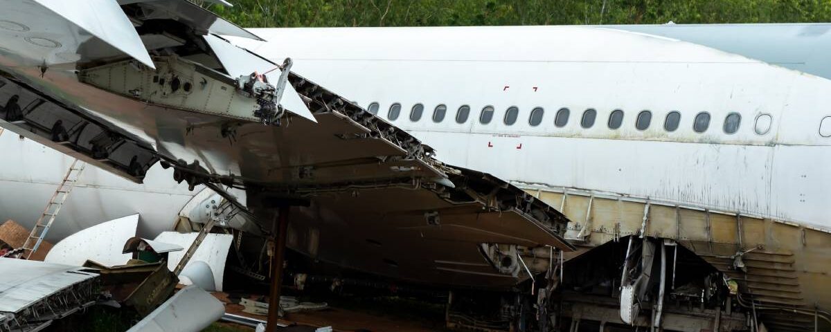 A large passenger airplane that has crashed to the ground. One wing has crumpled, and there are no people visible.