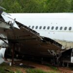 A large passenger airplane that has crashed to the ground. One wing has crumpled, and there are no people visible.