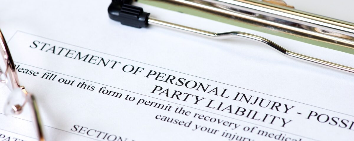 A close-up of a paper on a clipboard. The top of the page reads: “Statement of Personal Injury – Possible Party Liability.”