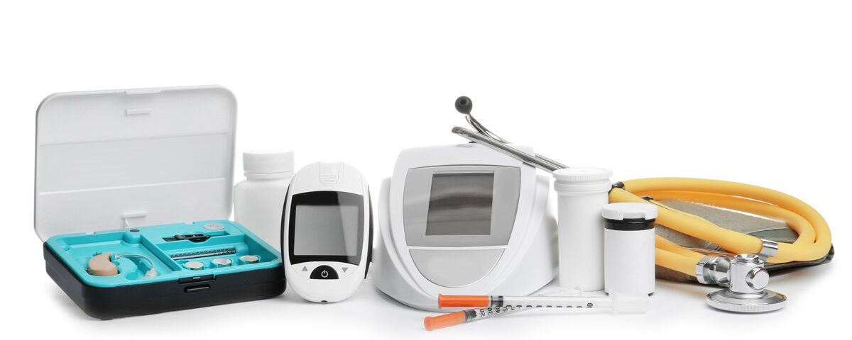 Several small medical devices, from a hearing aid set to a stethoscope, arranged in a line on a white background.