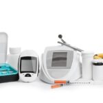 Several small medical devices, from a hearing aid set to a stethoscope, arranged in a line on a white background.