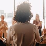 The backside of a businesswoman empowering other colleagues in the workplace during a quick team meeting.