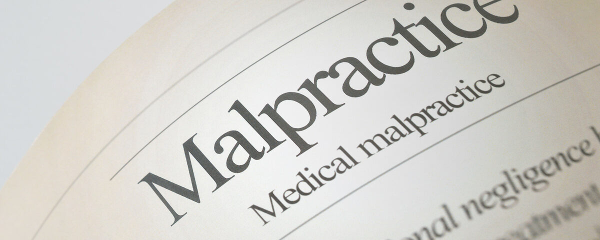 A close-up of a newspaper journal with the title "Malpractice; Medical Malpractice" at the very top.
